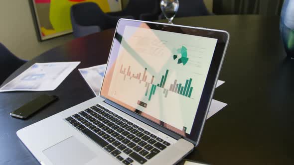 Close-up of laptop, mobile phone and documents on the table in conference room of modern office 4k