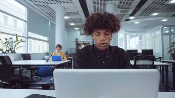 African American Employee Working on Laptop in Office