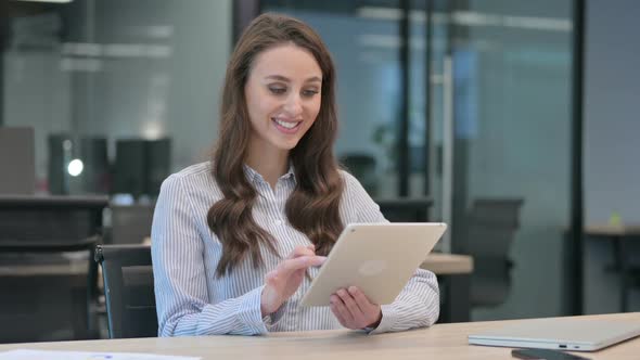 Successful Young Businesswoman Celebrating on Tablet at Work