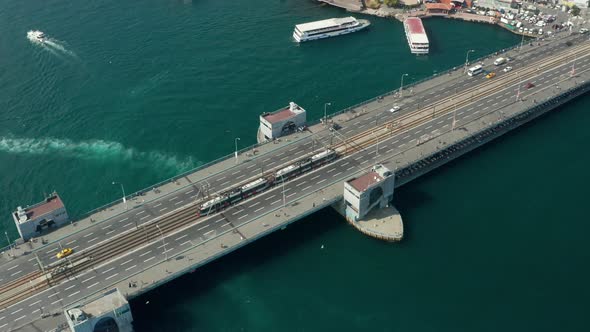 Public Transport Tram Train Passing Galata Bridge Over Bosphorus in Istanbul with Boats on Water