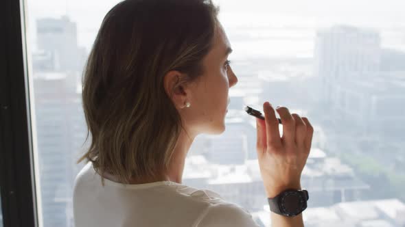 Profile of caucasian businesswoman thinking at window in office