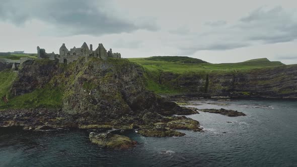 Ireland Dunluce Castle Ruins Aerial Shot on Greenery Basalt's Cliff