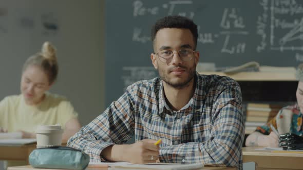 Portrait of Handsome Student at Desk in University