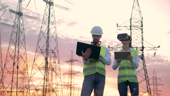 Electrical Transmission Lines and Two Engineers with Computers Work Using VR Headset.