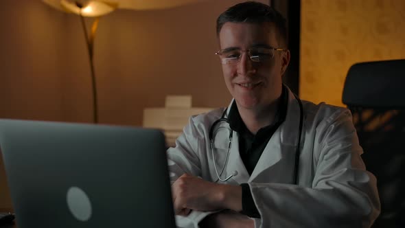 Beautiful Doctor with Glasses Smiles and Looks Into the Camera in Home Interior