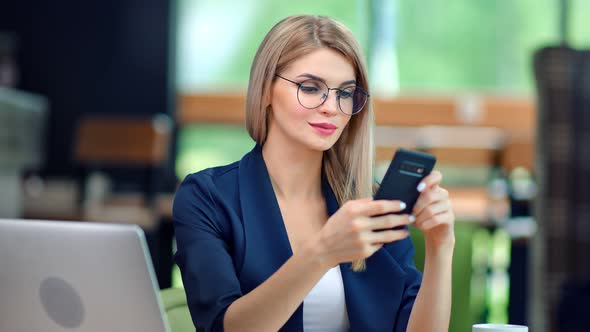 Fashionable Smiling Business Female in Stylish Glasses Chatting Using Smartphone Enjoying Break