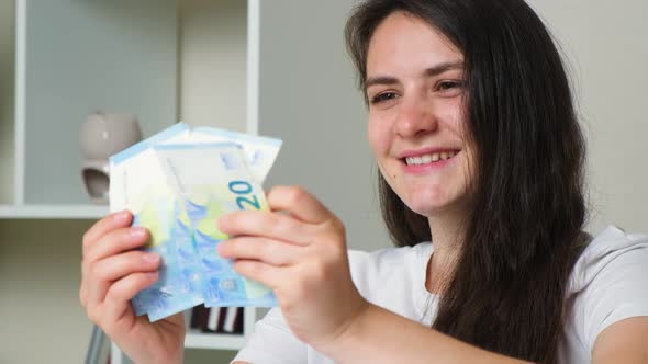 The Woman Counts the Bills for Twenty Euros and Smiles