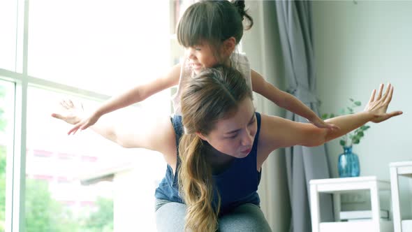 Asian Mother Practicing Yoga With Her Daughter 