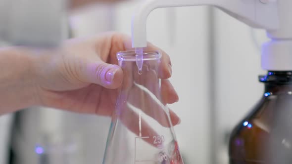 Close-up. The Laboratory Chemist Mixes the Recipes in a Volumetric Flask. COVID-19 Vaccine Research