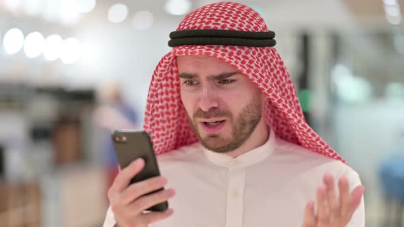 Portrait of Upset Arab Businessman Having Loss on Smartphone 