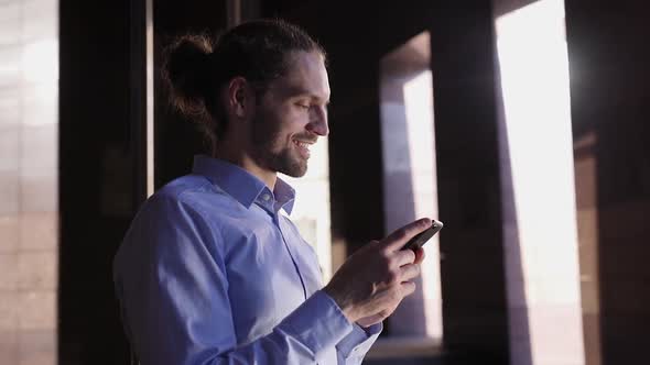 Business Man Using Mobile Phone Near Office Building