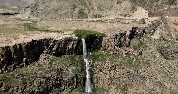 General aerial orbit of the inverted waterfall located in the Maule region, Chile on a sunny day.