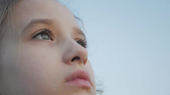 Profile of Young Girl Looking Up at Sunset Sky