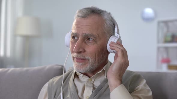 Positive Pensioner in Headphones Listening to Music Enjoying Favorite Radio