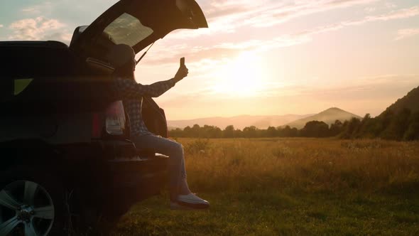 Female Photographs the Landscape Traveling By Car