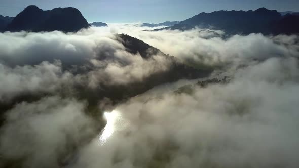 Aerial River Shines Under Sun Rays Through Scattering Fog