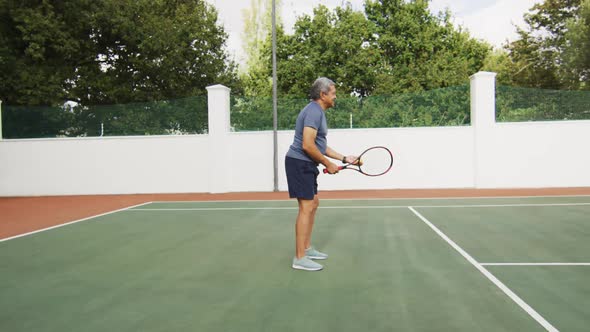 Video of biracial senior man holding racket and starting match on tennis court