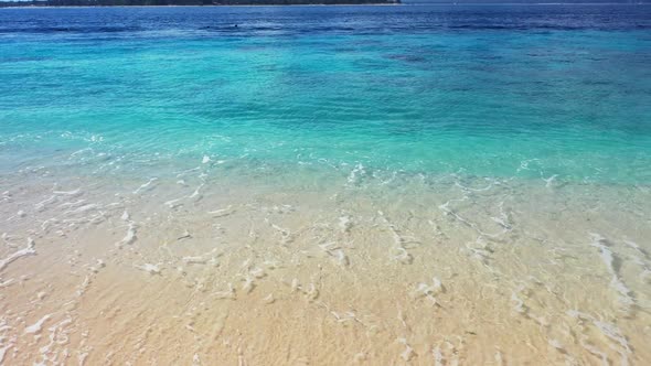 Aerial drone view scenery of tropical shore beach break by aqua blue ocean and bright sand backgroun