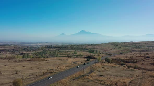 Aerial Drone Shot of Fields and Car Road on Background of Ararat Mountains