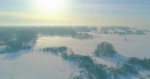 Aerial View of Cold Winter Landscape Arctic Field Trees Covered with Frost Snow Ice River and Sun