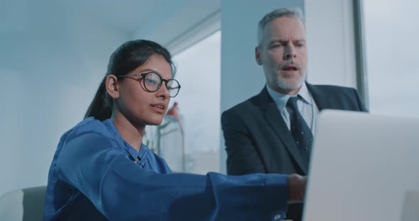 Young Indian woman presenting a project on the pc to a colleague