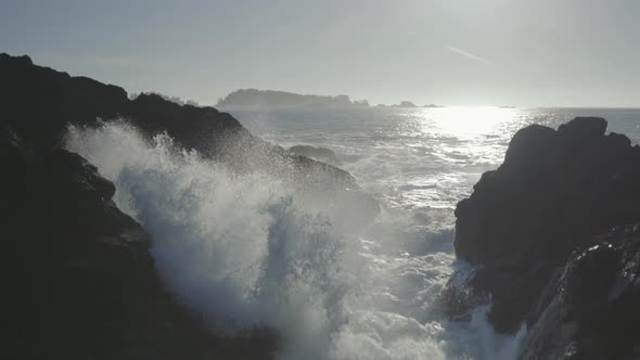 Static Slow motion close up shot of an ocean wave smashing on rock and splashing water in the air