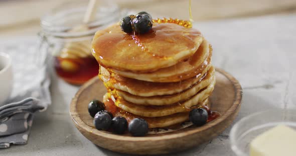 Video of pancakes on plate seen from above on wooden background