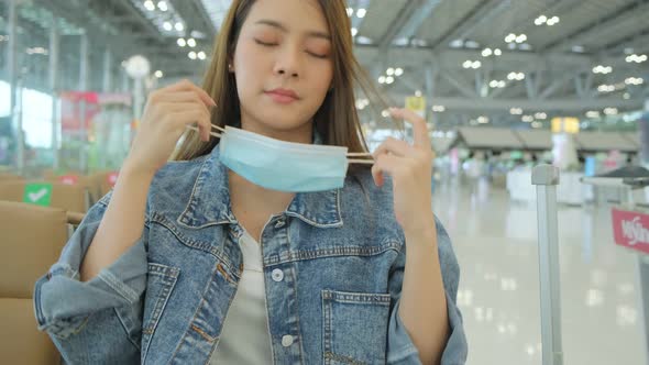 asian tourist traveller weaar protective face mask sit wait in new space social distancing