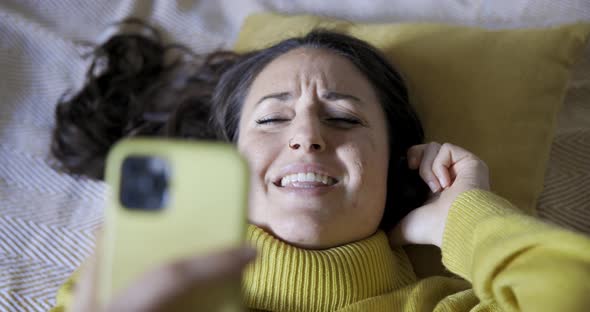 Authentic shot of woman on the bed listening to music and singing