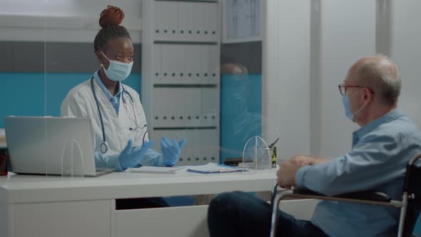 Woman Working As Medic Chatting with Old Invalid Man