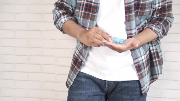 Young Man in Casual Dress Using Hand Sanitizer