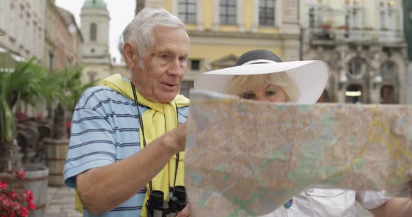 Senior Two Tourists Having Discussion About Planning Tourist Route in Lviv