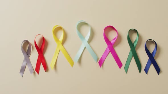 Video of close up of cancer ribbons on white background