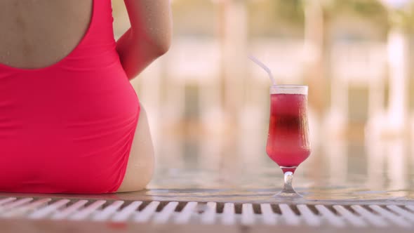 Hand of a Young Caucasian Girl Takes an Alcoholic Drink