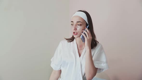 Young Woman with Collagen Pads Under Eyes Talks on Her Phone