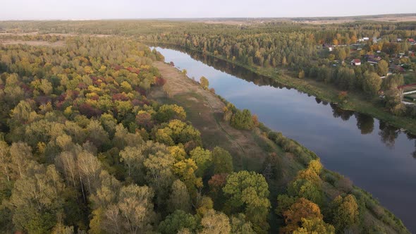 A View From a Quadcopter of a Wooded Area and a Calm River at Sunset
