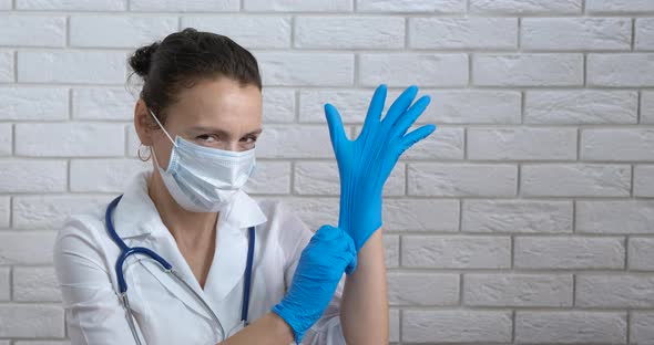 Doctor puts on protective gloves.