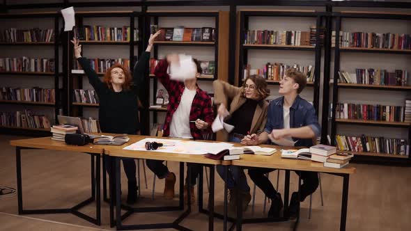 Slow Motion of Students Throwing the Sheets of Paper Up After Hours of Studying in Uni Library