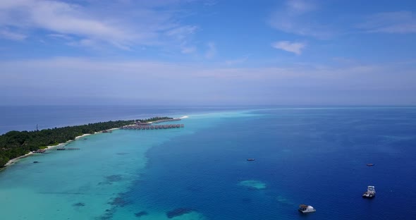 Wide angle flying abstract view of a white sandy paradise beach and aqua turquoise water background 