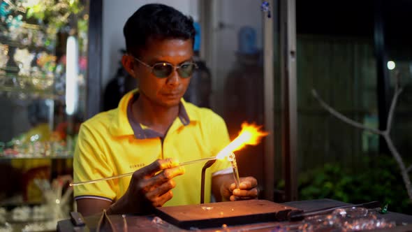 Senior man forming melted glass