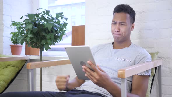 African Man, Designer Reacting to Loss, Using Tablet