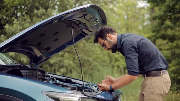 Sad Disappointed Man On Broken Car Accident.Car Problem.Trouble On Road..Car Engine Oil Level.