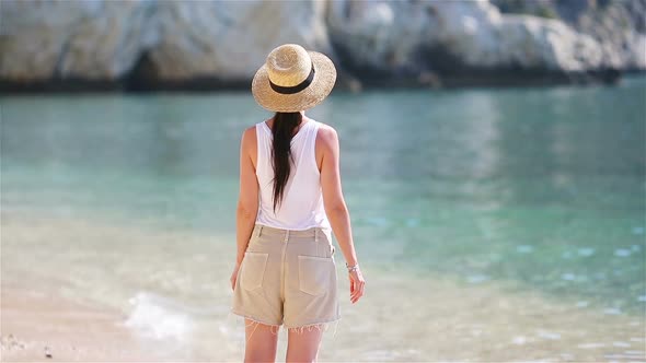 Young Beautiful Woman on White Sand Tropical Beach. Caucasian Girl in Hat Background the Sea