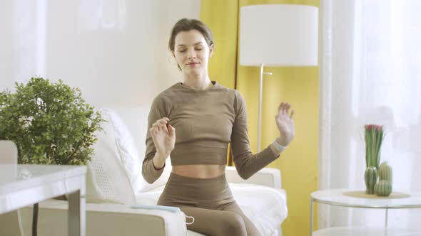 An Attractive Woman is Stretching and Lowering Her Hands