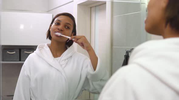 A Young Beautiful Woman Looks in the Mirror Brushes Her Teeth and Dances