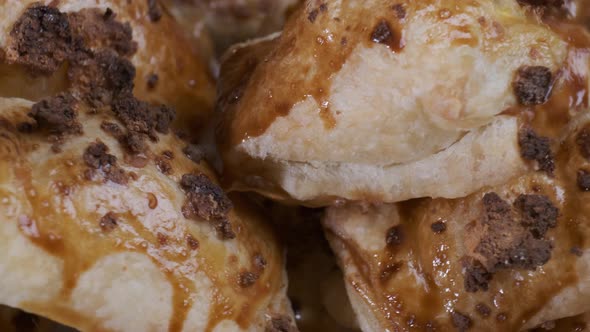 Baked puff pastry with toppings. Puffs with cheese on white plate rotating in front of camera