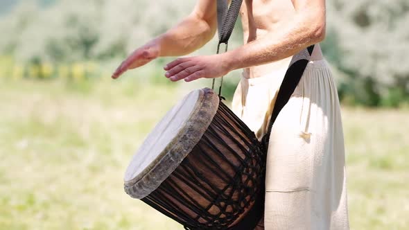 Unidentified Caucasian Man Playing African Djembe Drum