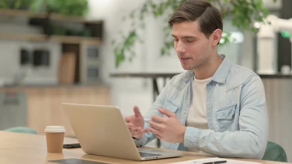 Creative Young Man Talking on Video Call on Laptop