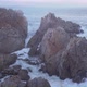 Aerial view over waves breaking onto rocks in the ocean - VideoHive Item for Sale