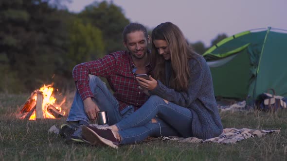Tourist Couple In Love With Phone Near Camping In Nature